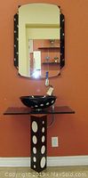 Assembled black-polka-dot pedestal vanity with glass vessel sink, glass countertop and mirror mounted on wall