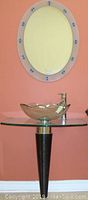 Assembled vanity showing glass vessel sink, tempered glass countertop, single-handle faucet, black ribbed pedestal and oval mirror