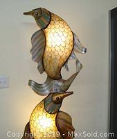 Close-up of dolphin fish design with illuminated scales showing gold and silver metal finish details.