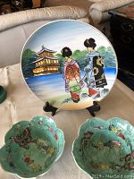 Overall view of hand-painted china plate and two green glazed lotus leaf rice bowls