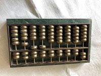 Photo of brass abacus showing rectangular frame and beads.
