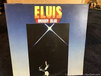 Front cover of Elvis Presley Moody Blue album with large title and star image.