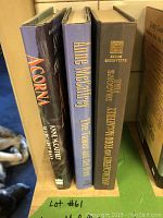 Photo showing three hardback books standing vertically on a shelf: 'Acorna', 'The Tower and the Hive', and 'Dragons' Fire'