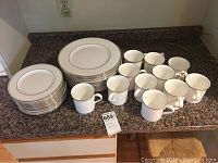 Full set showing cups, lunch, and dinner plates with platinum trim on granite counter