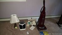 Photo of all lot contents together including Kenmore vacuum, Singer sewing machine, bathroom scale, table lamp and vacuum bags
