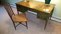 Full view of Asian motif green wooden desk paired with cane woven seat chair