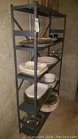 Gray metal shelving unit with dishes on shelves showing size and condition