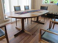 Full view of oval dining table with leaf in place and pedestal bases