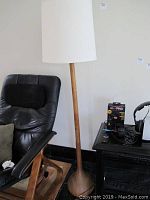 Front view of floor lamp next to chair and table