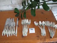 Overview of all flatware pieces arranged on table, grouped by type