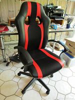 Front view of the red and black adjustable rolling office chair showing seat, backrest, armrests, and caster wheels.
