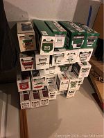 Stack of 27 boxes containing Hess Trucks and collectibles in original packaging, stacked against a wall.
