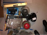 Top view showing Guitar Hero guitar controller and two gumball machines (one with red lid). Other boxed items around including chess sets.