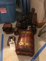 Overview of all silver plated items and wood boxes on floor showing arrangement and scale.