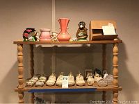Shelf view showing pink vases, monkey incense burner, box and lower shelf of porcelain egg boxes