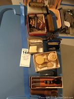 Photo showing multiple wooden and clay smoking pipes along with boxes containing pipe cleaners, small containers, and other collectibles.