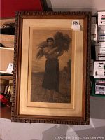 Full view of antique print in original wooden frame, showing woman holding wheat bundle in a field.