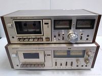 Front view of two vintage Sony cassette decks stacked, showing control buttons, cassette windows, and analog VU meters