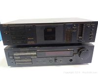Front view of Nakamichi BX-100 cassette deck stacked on Nakamichi RE-3 stereo receiver showing all main controls and cassette slot.