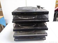 Stacked view of all five vintage turntables showing front panels and dust covers.
