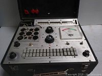 Front view of tester showing tube socket bank, rotary voltage selectors, push-button circuit keys and analog meter gauge