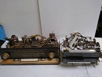 Two vintage tube radios side by side showing front panels and exposed internals for parts.