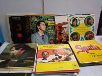 Photo showing a selection of vinyl record album covers from the lot featuring various artists and musical styles, including classical guitar and international themes.