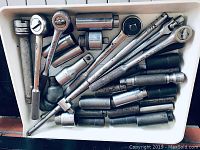Overview shot of all sockets, ratchets, extensions and wrenches in white tray.