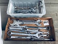 Overview of multiple wrenches in two containers including open-end, box-end, and combination types, plus adjustable pipe wrench.