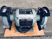 Top view of the Delta 6 inch bench grinder showing label details, grinding wheels and mounting on wooden base.
