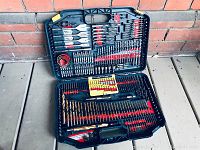 Open case showing drill bits, screwdriver bits, spade bits, hole saw, and holder all arranged in molded slots