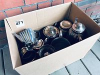 Overhead view of box showing multiple silver-plated items including fan-shaped teapot and various pots and containers