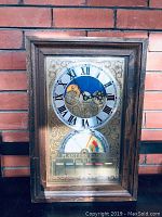 Full front view of the vintage Planter's Clock showcasing the wooden frame, Roman numeral clock face with celestial design, and the planting guidance dial below.
