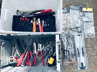 Top view of white plastic bin containing various hand tools including a set of precision screwdrivers, rivet gun, wooden glass cutter, wire stripper, small wrench, packaged clamps, and yellow screwdriver.