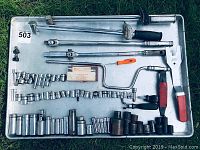 Full overview photo of all the Snap-On mechanic's tools laid out on a metal tray, showing assortment of sockets, ratchets, extensions, and specialty handles