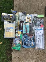 Full overview photo showing all tools and storage box spread on a concrete surface.