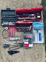 Full overview of all mechanic tools laid out on concrete, showing multiple sets of sockets, ratchets, hex keys, and hand tools.