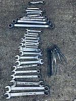 View of entire lot laid out on concrete showing all wrenches and pliers