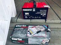 Front view of Powerfist battery charger showing model, amperage, and features.