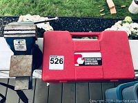 Bench vise and McPherson strut spring hook compressor case side by side showing both items in lot.