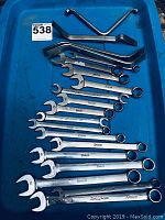 Full set of Snap-on wrenches and tire irons laid out on blue surface, all visible including sizes and branding