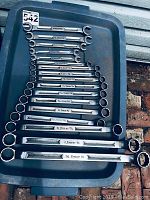 Full set of 12 combination wrenches laid out on blue plastic tray.