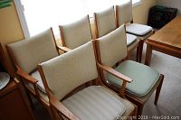 Six teak dining chairs grouped together
