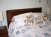 Wood framed double bed headboard with bedding including comforter and decorative pillows