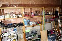 Full view of three-section wooden shelving unit with various items on shelves, minor wear visible on wood