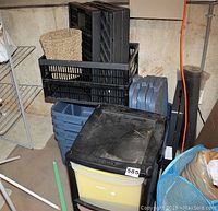Photo of plastic storage unit, Rubbermaid totes stacked, collapsible bins, and blue mesh laundry basket with contents.