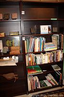 Bookshelves showing books of various genres, motivational coasters, and boxes
