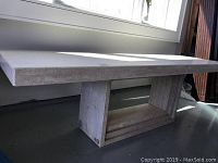 Front view of marble console table under window