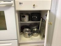 Cabinet with assortment of pots, pans and metal baking trays