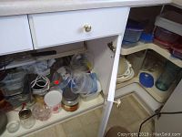 Kitchen cabinet and shelf with multiple plastic containers and Tupperware items